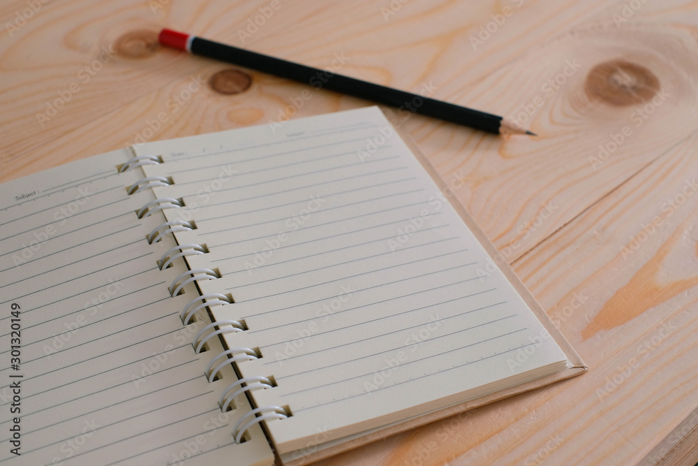 notebook and pen on wooden background