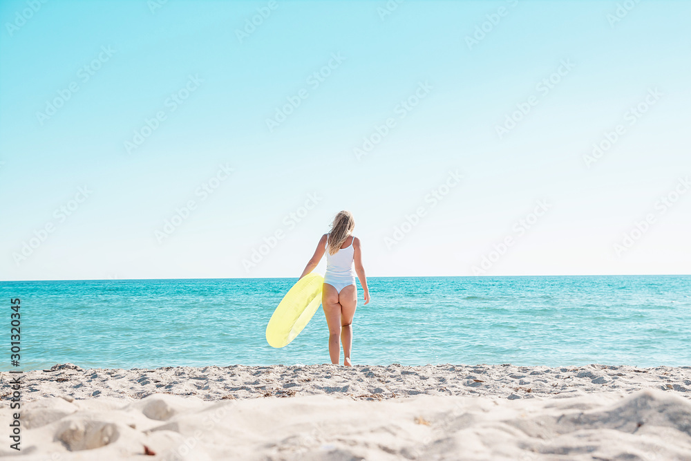 Girl goes swimming on the beach with a rubber ring