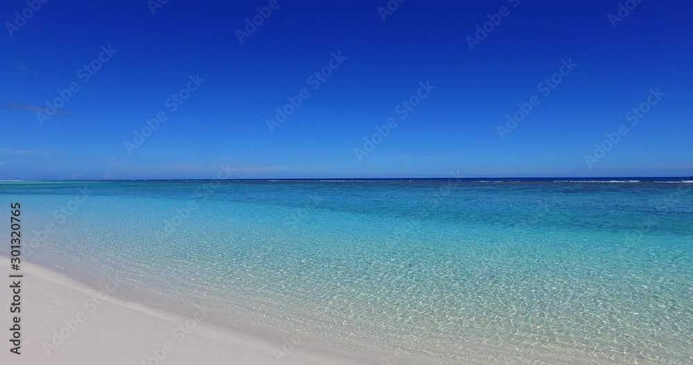 Still seascape with open blue sky and tranquil turquoise lagoon washing white fine sand of exotic beach in Turks and Caicos islands Still seascape with open blue sky and tranquil turquoise lagoon washing white fine sand of exotic beach in Turks and Caicos islands