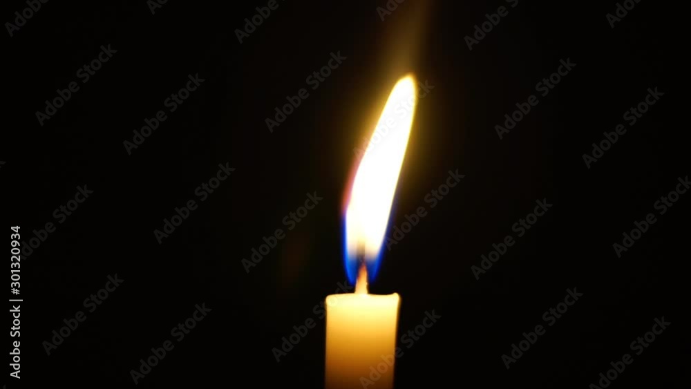 One candle light illuminated in a black background. One candle light illuminated in a black background.