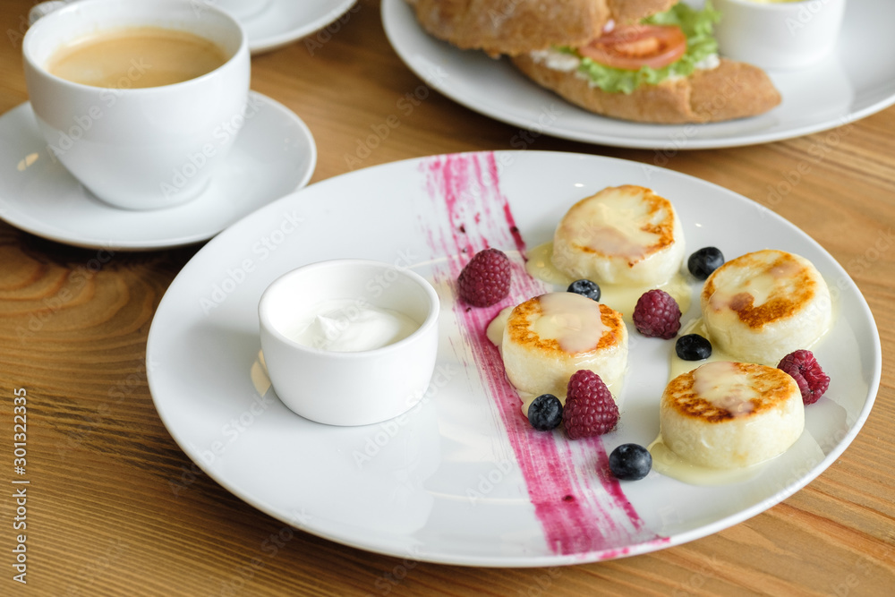Delicious curd cheesecakes with raspberry and blueberry berry sauce. restaurant food concept Delicious curd cheesecakes with raspberry and blueberry berry sauce. restaurant food concept