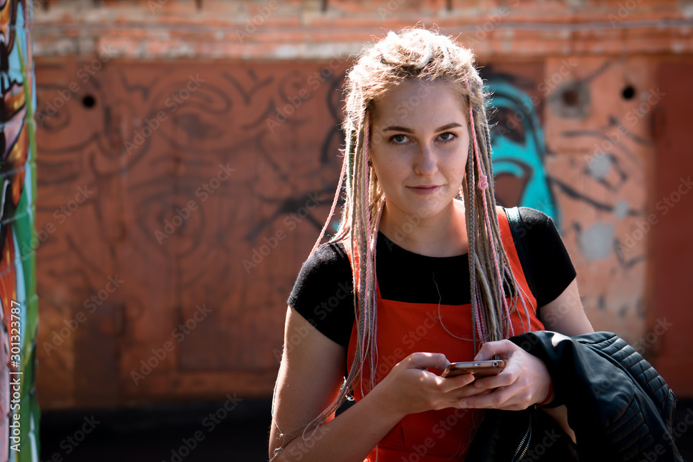 Obraz premium portrait of young woman with mobile phone at summer time