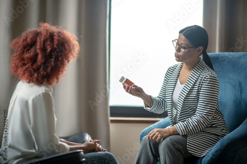 Foto Dark-haired psychoanalyst recommending sleeping pills to client