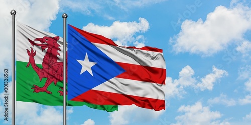 Wales and Puerto Rico flag waving in the wind against white cloudy blue sky together. Diplomacy concept, international relations.