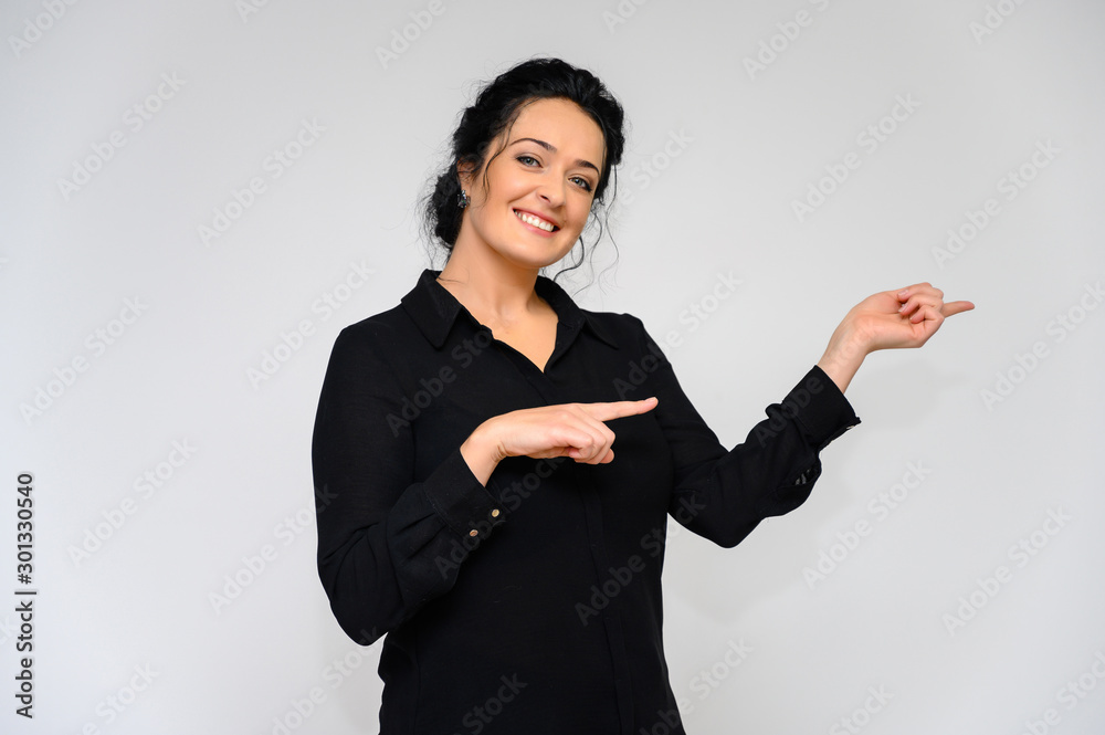 Business woman concept. Portrait of a pretty brunette woman on a white background in a black blouse. He stands in front of the camera, smiles, talks in various poses with emotions. Business woman concept. Portrait of a pretty brunette woman on a white background in a black blouse. He stands in front of the camera, smiles, talks in various poses with emotions.