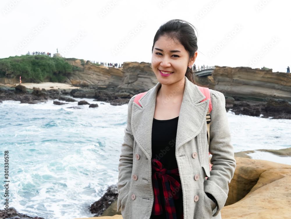 Beautiful Asian woman, girl with a jacket standing and smile, take a photo beside the sea in her travel. Beautiful Asian woman, girl with a jacket standing and smile, take a photo beside the sea in her travel.