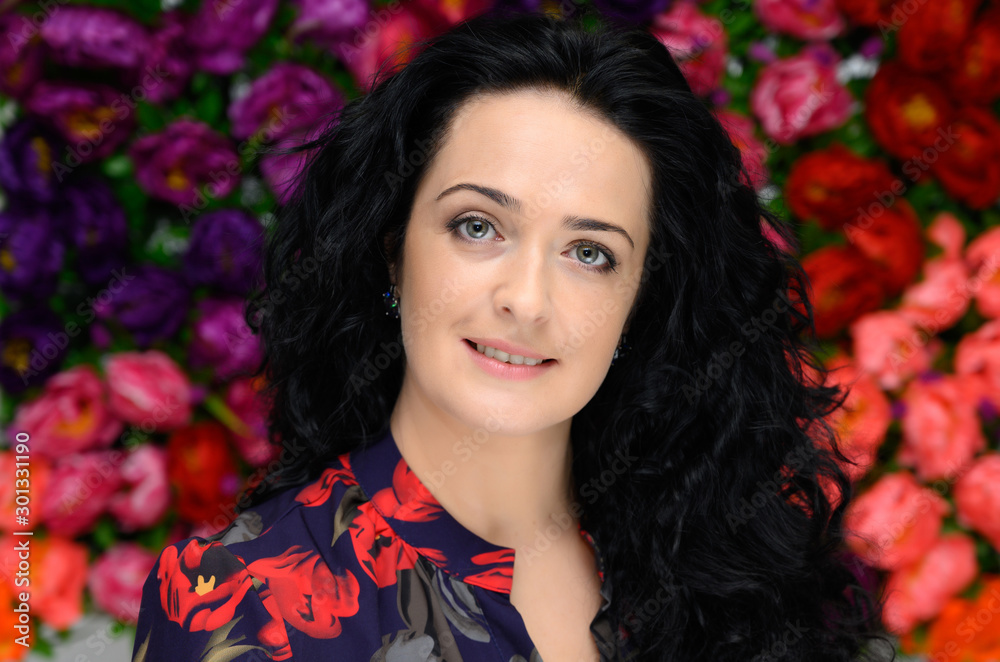 Beauty concept. Age-related cosmetics. Portrait of a pretty brunette woman with long curly hair on a colored background with a beautiful face and good makeup. In front of the camera, smiling. Beauty concept. Age-related cosmetics. Portrait of a pretty brunette woman with long curly hair on a colored background with a beautiful face and good makeup. In front of the camera, smiling.