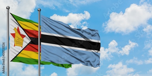 Zimbabwe and Botswana flag waving in the wind against white cloudy blue sky together. Diplomacy concept, international relations.