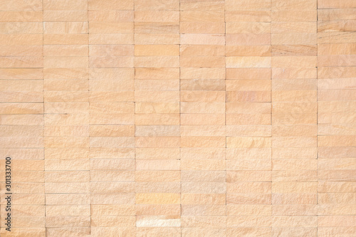 Rock tile wall texture background in natural light yellow cream