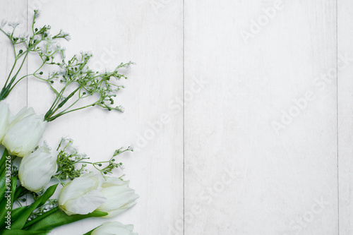 Fototapeta Naklejka Na Ścianę i Meble -  Spring tulip flowers and paper card on gray stone table from above in flat lay style. Greeting for Women's or Mothers Day