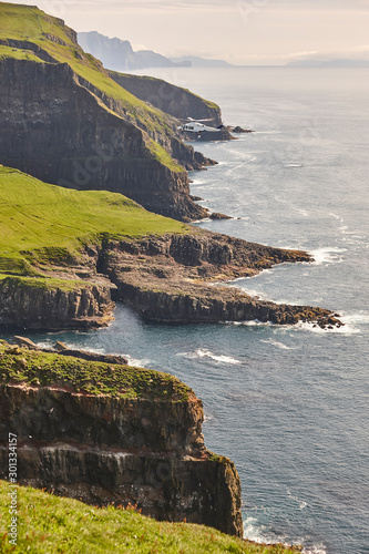 Helicopter flying over mykines atlantic cliffs in Faroe islands. Transportation photo