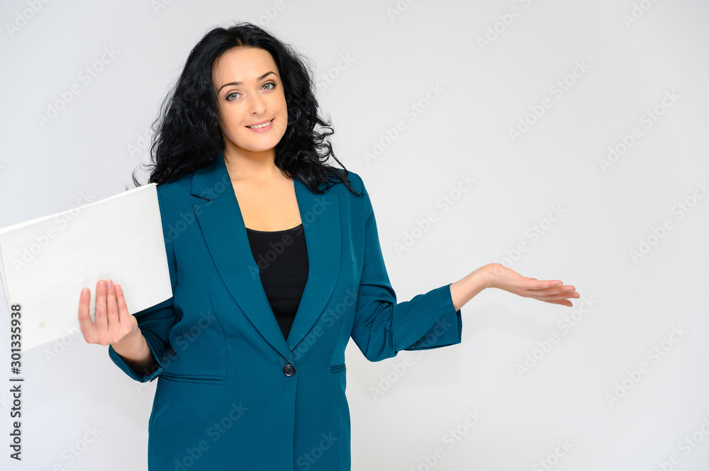 Portrait of a pretty brunette woman with long curly hair on a white background in a business suit with a folder in her hands. He stands in front of the camera, smiles, talks in various poses. Portrait of a pretty brunette woman with long curly hair on a white background in a business suit with a folder in her hands. He stands in front of the camera, smiles, talks in various poses.