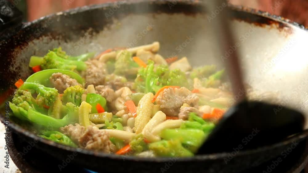 Frying mixed vegetables with pork in pan, outdoor Chiangmai Thailand Frying mixed vegetables with pork in pan, outdoor Chiangmai Thailand