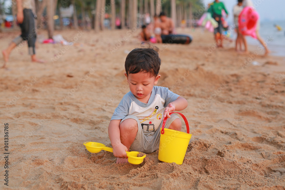 Adorable little Asian baby boy playing sand at beach. Adorable little Asian baby boy playing sand at beach.