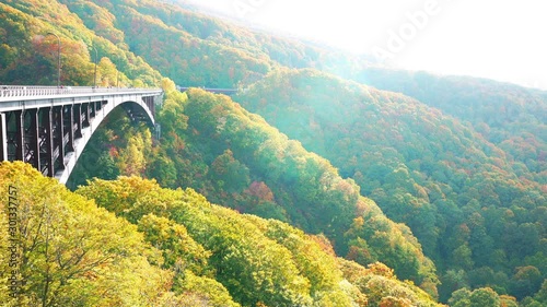 View of Jogakura Bridge in sunlight with the beautiful mountain and the colorful foliage in autumn season in Towada-Hachimantai National Park, at Aomori, Japan photo