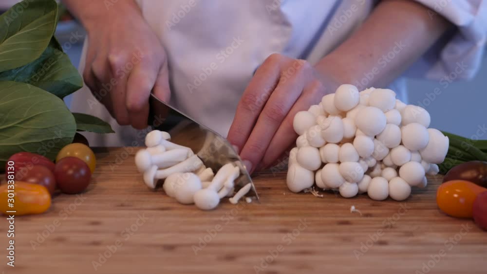 close up shot of chef cutting small white mushrooms for the dish close up shot of chef cutting small white mushrooms for the dish