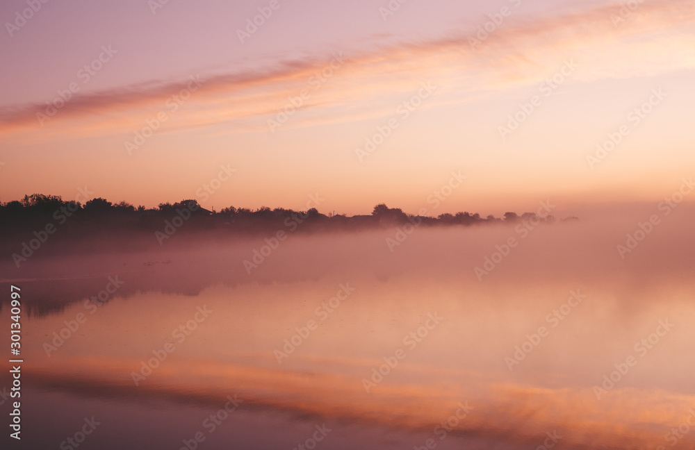 The lake at sunrise and above it is fog