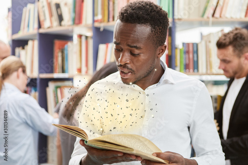 African man looks in awe at book photo