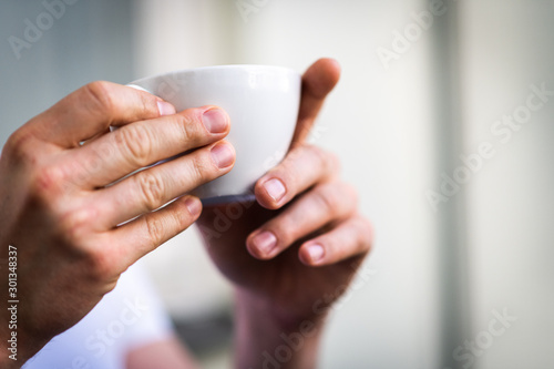 the white cup and the hands of the man, isolated from background and focused  