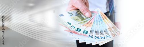 Man hand holding euro notes; panoramic banner photo