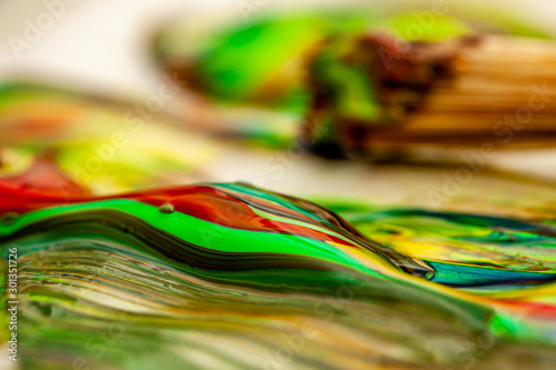 Close up of liquid artist colours on brush and pot photo