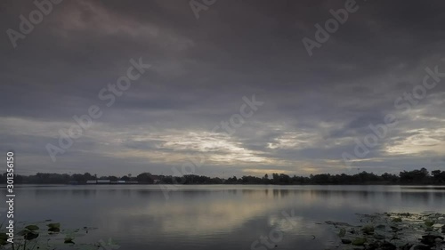 Time lapse of dark clouds moving above the lake with rain storm in the sky background, Krajub reservoir, Nonk Kop in Ban Pong District, Ratchaburi, Thailand. photo