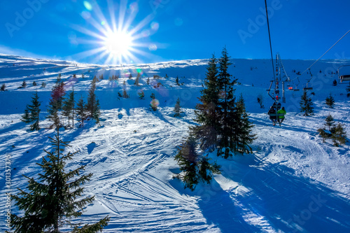 Bright Sun over an Unequipped Ski Slope and Chair Lift photo