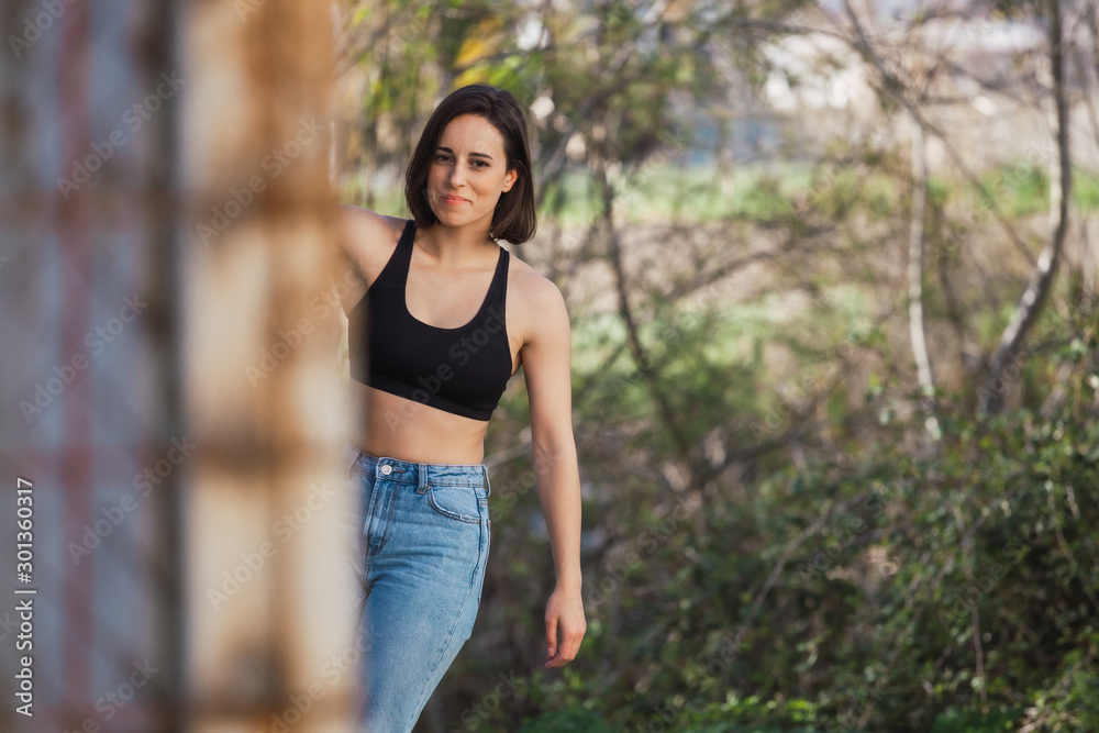 Young woman skater grabs ancient metal fence freedom concept