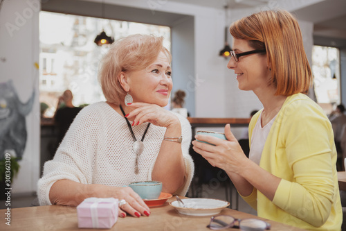 Mature woman meeting her senior mother at the coffee shop