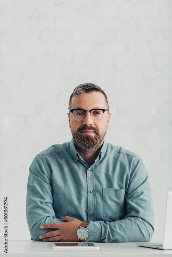 handsome businessman in shirt and glasses looking at camera in office handsome businessman in shirt and glasses looking at camera in office
