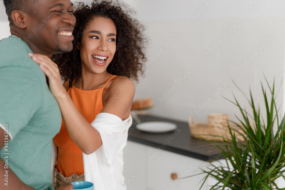 Beautiful young couple hugging and laughing at home Beautiful young couple hugging and laughing at home