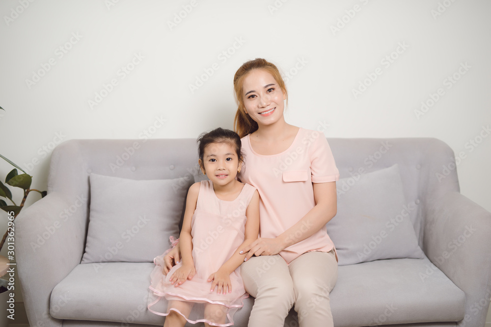 mother and girl smiling in the living room mother and girl smiling in the living room