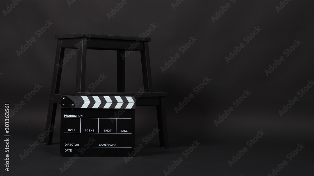 Clap board or movie slate and chair. It is use in video production , movie ,film, cinema industry on black background.