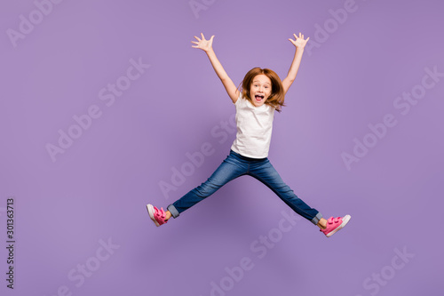 Full length photo of funny small foxy lady jumping high rejoicing making star shape in air cheerful crazy mood wear casual t-shirt jeans isolated purple background photo