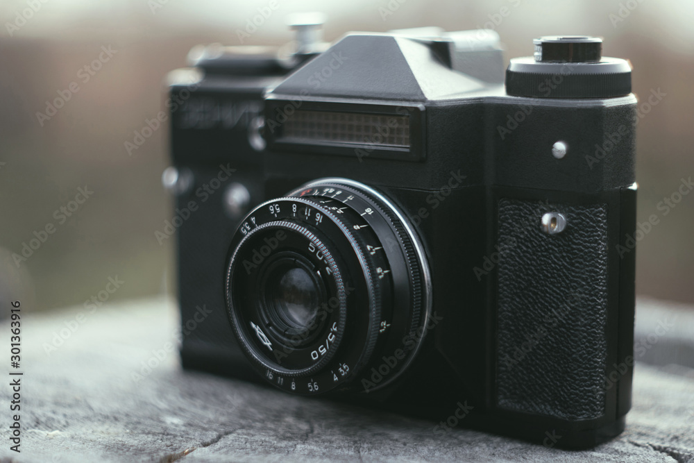 Stylish vintage film camera, old retro technology at old wood, blurred brown background