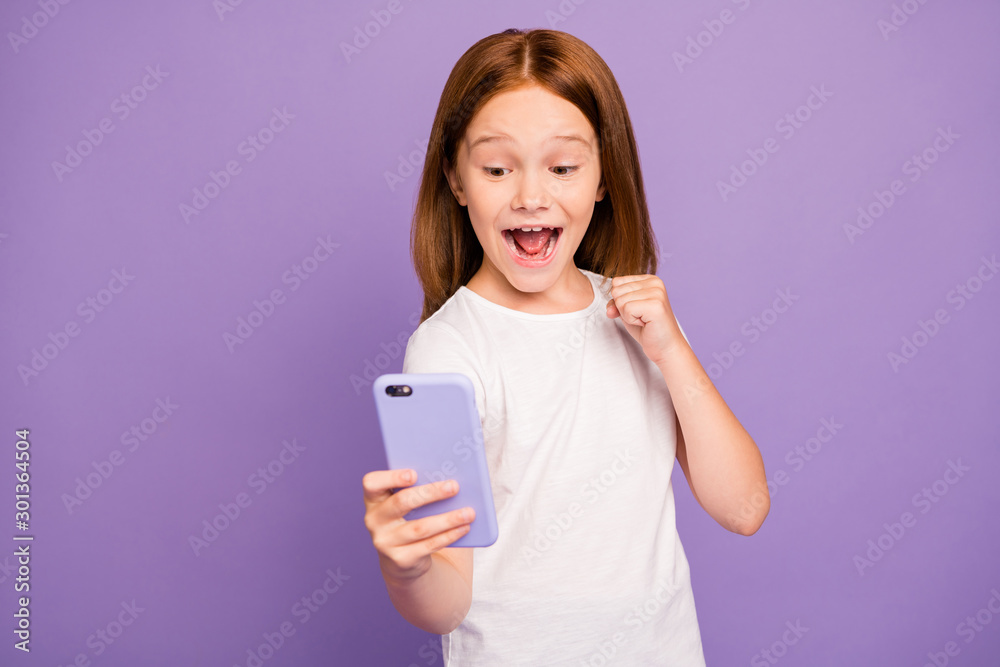 Photo of funny small excited foxy lady holding telephone hands checking blog excited with many new followers subscribers wear white t-shirt isolated purple background Photo of funny small excited foxy lady holding telephone hands checking blog excited with many new followers subscribers wear white t-shirt isolated purple background