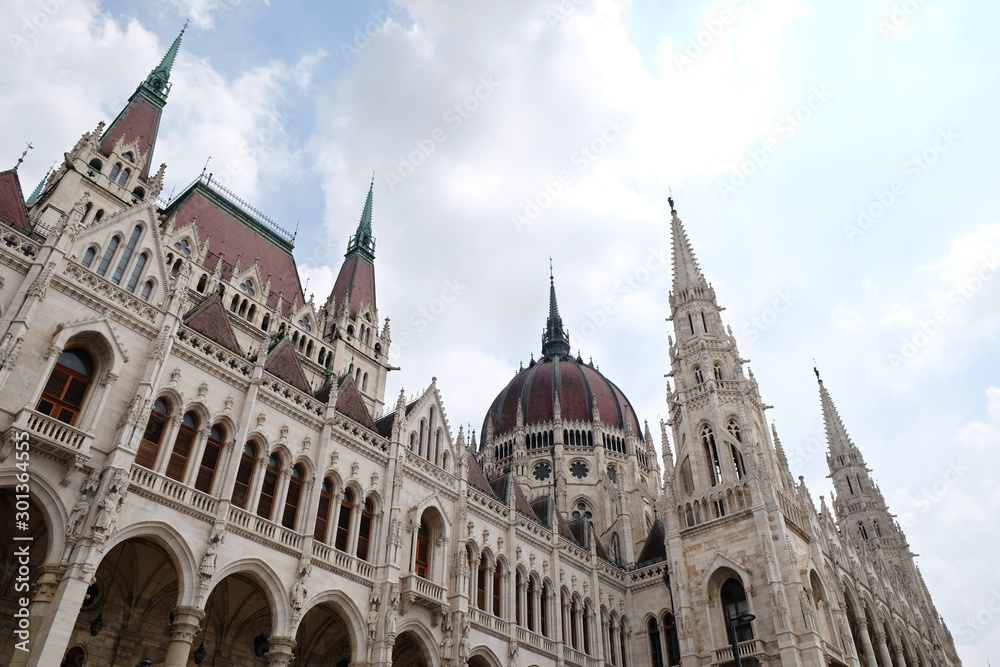 View of historical building of Hungarian Parliament in Budapest, Hungary, Europe on background of bright blue cloudy sky