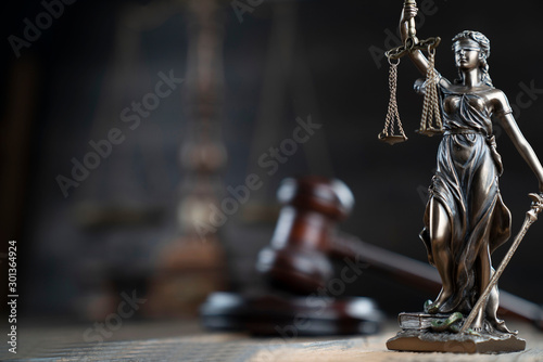 Justice concept. Themis statue and judge's gavel on the dark background.