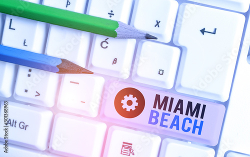 Writing note showing Miami Beach. Business concept for the coastal resort city in MiamiDade County of Florida photo