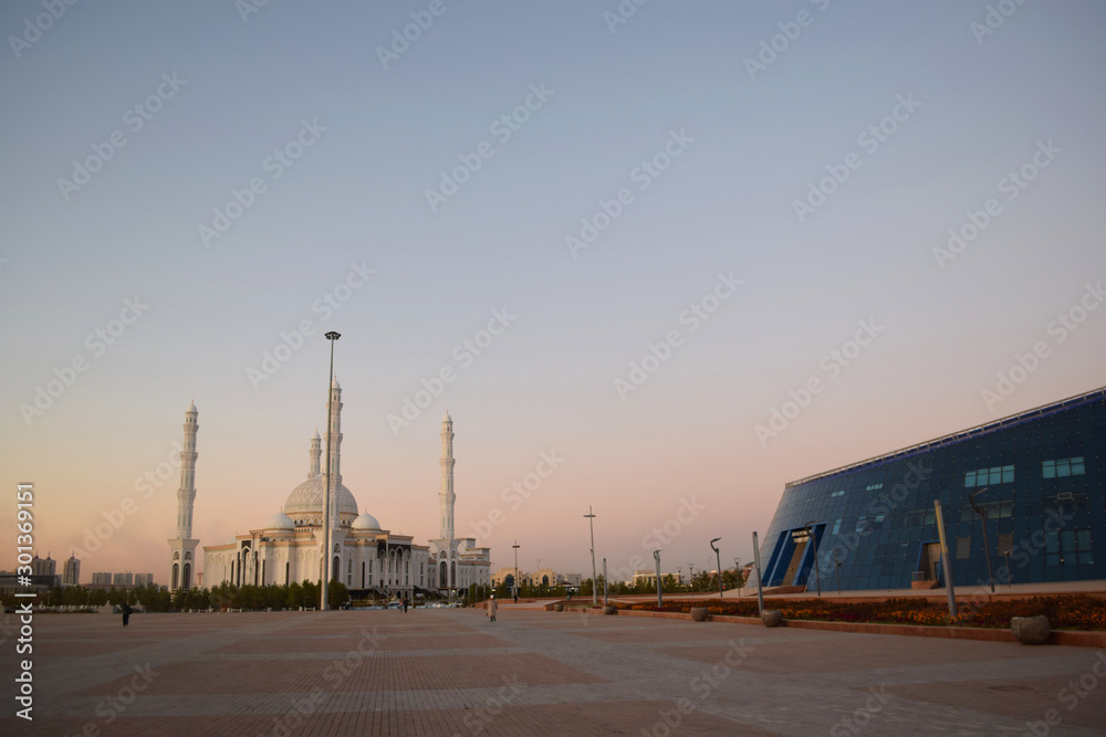 mosque meets modern architecture at sunset