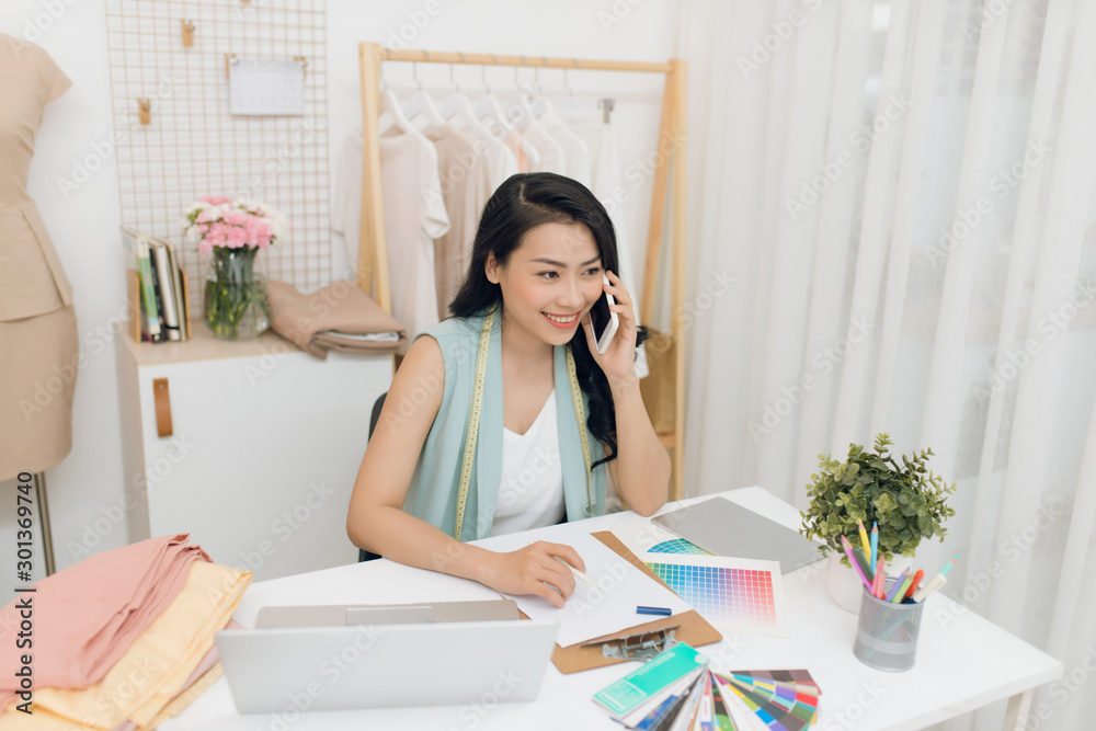 Young Asian entrepreneur women / fashion designer working on her atelier Young Asian entrepreneur women / fashion designer working on her atelier