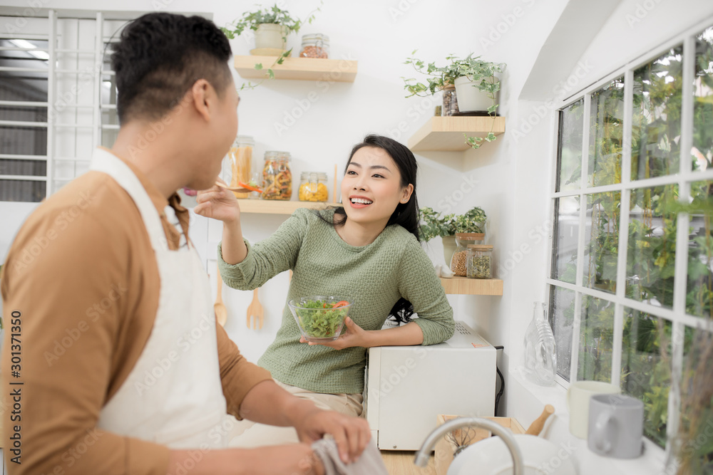 Asian couple eating breakfast early in the morning in the kitchen and having a good time. Asian couple eating breakfast early in the morning in the kitchen and having a good time.