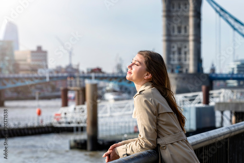 Portrait einer brünetten Frau am Ufer der Themse vor der Tower Brücke von London, Großbritannien