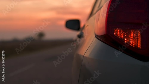 Blinking car tail lights on the road in autumn sunset photo