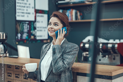 Woman with cellphone in small coffee point stock photo