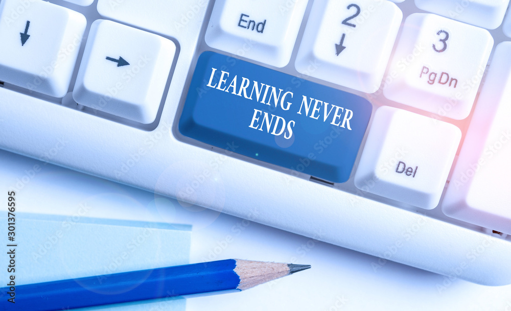 Conceptual hand writing showing Learning Never Ends. Concept meaning Life Long Educational and Wellness Opportunities White pc keyboard with note paper above the white background