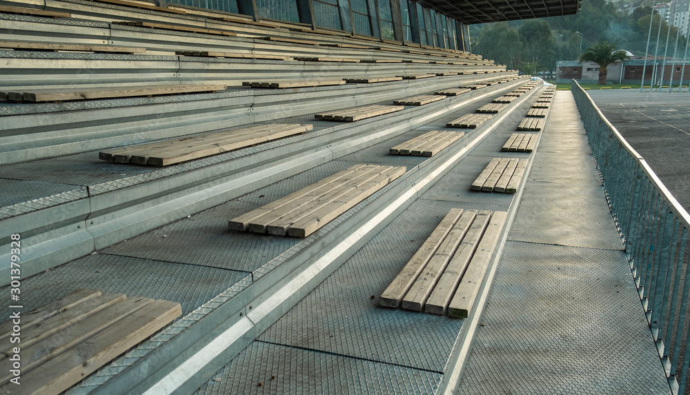 Empty stadium seats, wooden bench.