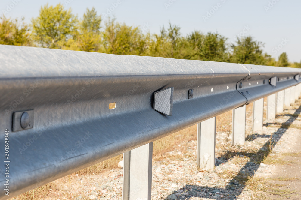 white road reflectors along the road. metal road fencing of barrier type, close-up. Road and traffic safety white road reflectors along the road. metal road fencing of barrier type, close-up. Road and traffic safety