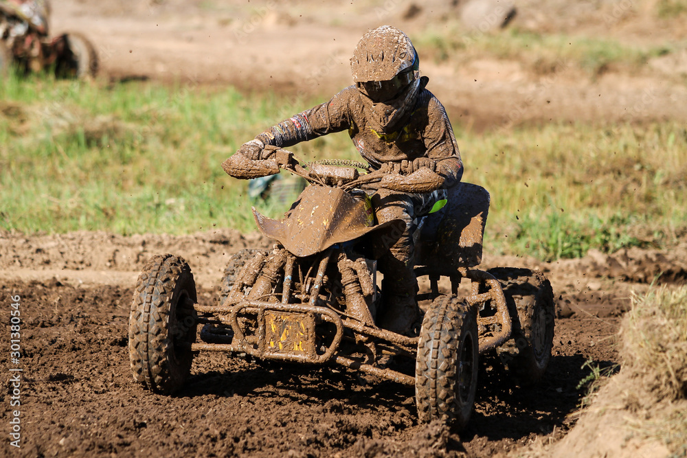 Motocross quad race with races who are covered with mud in an old motocross track. Motocross quad race with races who are covered with mud in an old motocross track.
