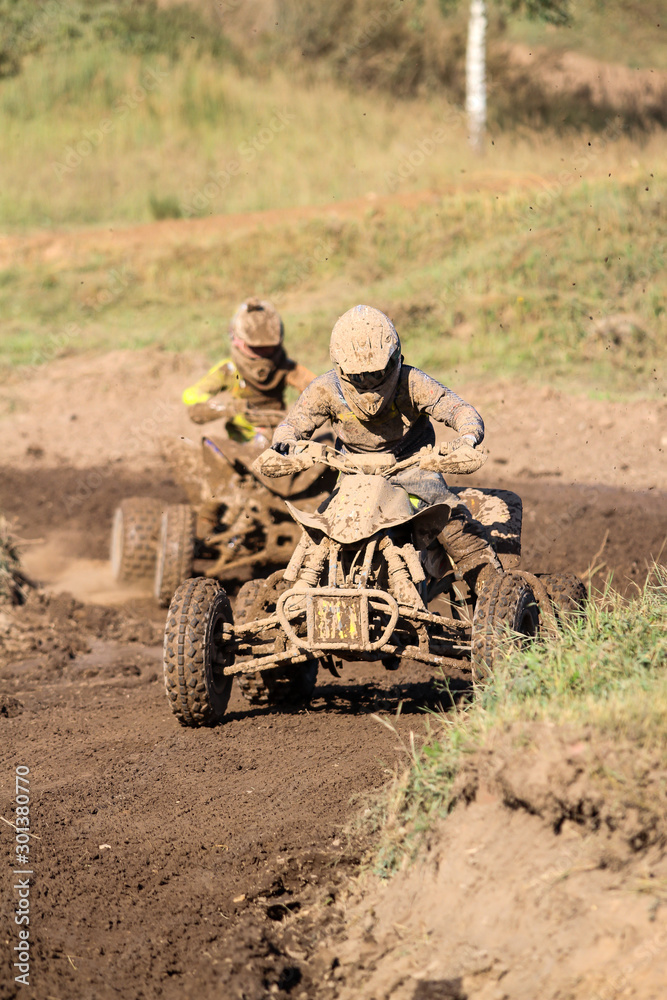 Motocross quad race with races who are covered with mud in an old motocross track. Motocross quad race with races who are covered with mud in an old motocross track.